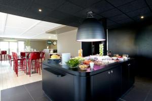 a kitchen with a counter with food on it at Campanile Lille Sud - CHR in Lille