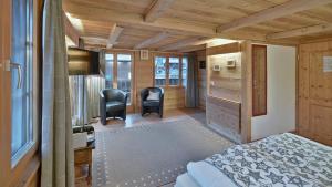 um quarto com uma cama e duas cadeiras num quarto em Hotel Restaurant Les Lilas em Les Diablerets