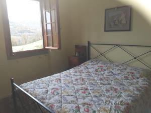 een slaapkamer met een bed met een quilt bij App.to Pian del Ronco in Pellegrino Parmense