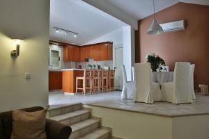 cocina y sala de estar con mesa y sillas en Nestor Hillside House by TrulyCyprus en Moniatis
