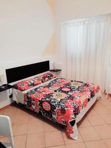 a bedroom with a bed with a flowered blanket at Fontanarossa Airport Home in Catania