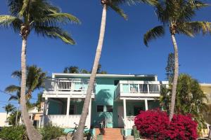 a house on the beach with palm trees at LICENSED MGR - 2/2 VILLA - OCEANFRONT BEACH RESORT - SALTWATER LAGOON & MARINA! in Key Largo