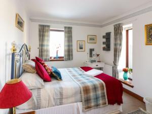 a bedroom with a bed and a red lamp at Stunning 7 Bedroom Bungalow Alford Aberdeenshire in Alford
