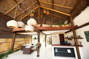 a living room with a ceiling with wooden beams at Pousada Enseada Dos Golfinhos in Pipa