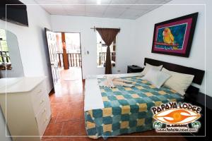 a bedroom with a bed with a colorful blanket at Papaya Lodge in La Libertad