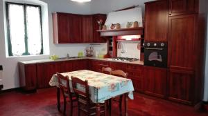 a kitchen with wooden cabinets and a table with chairs at Villa di San Gervasio in San Gervasio Bresciano