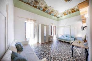 uma sala de estar com um sofá e uma cama em Casanova Rooms and Apartment to Rent em Cefalù