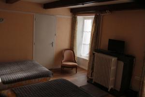 a room with a bed and a chair and a window at Hostellerie du Beffroy in Besse-et-Saint-Anastaise