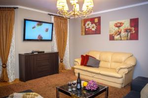 sala de estar con sofá y TV de pantalla plana en ORNAVA Boutique Apartments, en Ternopilʼ
