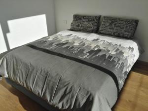 una camera da letto con un letto con un piumone e cuscini grigi di Villa Belvedere a Valdidentro