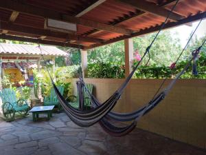 a hammock hanging from a porch with chairs at Bananoz Surfhouse in Transito