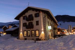 a building in the snow at night in a town at Castellani Livigno Apartments in Livigno