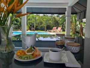 a table with a plate of fruit and a cup of coffee at Centro de Santiago in Santiago de los Caballeros