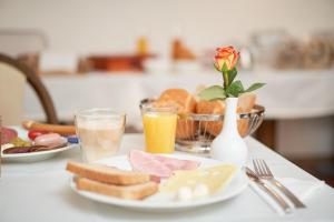 einen Tisch mit einem Teller Essen und zwei Gläsern Orangensaft in der Unterkunft Hotel Moguntia in Mainz