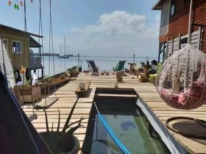 una terraza de madera con piscina junto al océano en Life is good casa, en Istmito