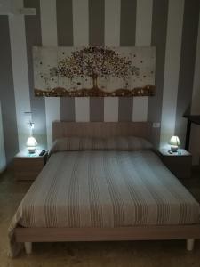 ein Schlafzimmer mit einem Bett mit zwei Lampen an zwei Tischen in der Unterkunft APP. TURISTICO ARCO NORMANNO in Mazara del Vallo