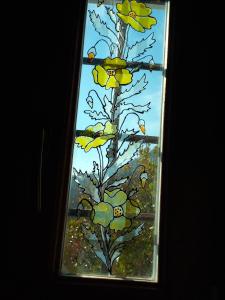 una vidriera con un árbol con flores amarillas en Guesthouse Kalosorisma en Tsagarada