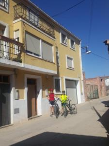 dos personas en bicicleta delante de un edificio en Can Valleta, en Bot