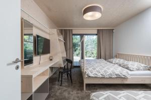 a bedroom with a bed and a desk with a computer at Chalet Bedřichov in Bedřichov