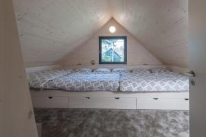 Una cama blanca en una habitación con ventana. en Chalet Bedřichov, en Bedřichov 27 fotos más