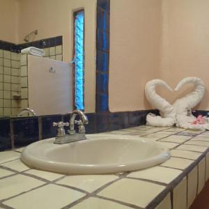 a bathroom with a sink and two swan towels at Agua Azul la Villa in Santa Cruz Huatulco