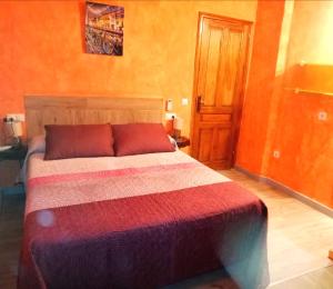een slaapkamer met een bed met een kleurrijke sprei bij Casa con jacuzzi la olivera in Chert