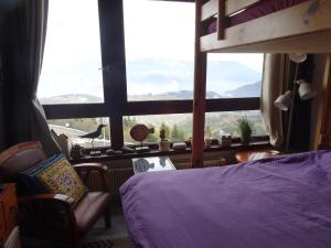 ein Schlafzimmer mit einem Bett und einem großen Fenster in der Unterkunft STUDIO Prapoutel in Prapoutel