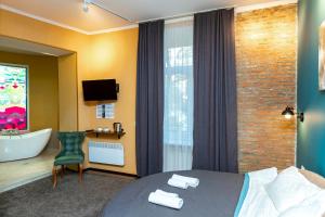 Hotello في تبليسي: غرفة الفندق بسرير وحمام مع حوض استحمام