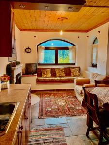 a living room with a couch and a large window at Elati's traditional and cosy home in Eláti