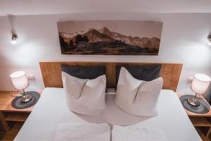 マトライ・イン・オストティロルにあるZöschgenhofのベッド1台(白い枕2つ、ランプ2つ付)