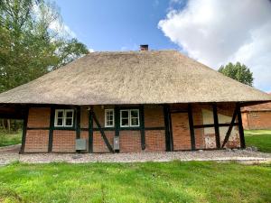 an old brick building with a thatched roof at Reetdachkate in Neukirchen