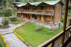 una grande casa in legno con tetto verde di HOTEL IGUAIMA a Ibagué