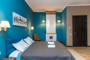 a blue bedroom with a bed with blue walls at Hotello in Tbilisi City