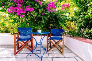 a table and two chairs and pink flowers at Casa Di Roma in Parikia