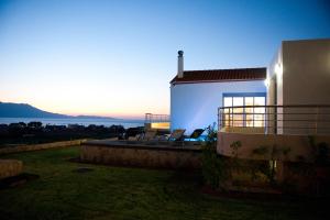 a house with a balcony with a view of the ocean at Anemon Villas in Kissamos