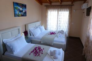 Habitación de hotel con 2 camas con flores rosas. en Vila Cerca de Mar, en Ksamil