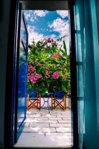 an open door to a patio with pink flowers at Casa Di Roma in Parikia