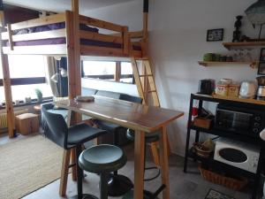 - une table et des chaises dans un dortoir avec des lits superposés dans l'établissement STUDIO Prapoutel, à Prapoutel