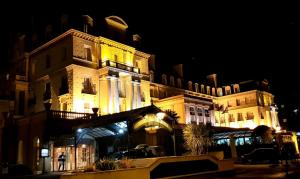 a large building with lights on it at night at La Coloniale in Saint Malo