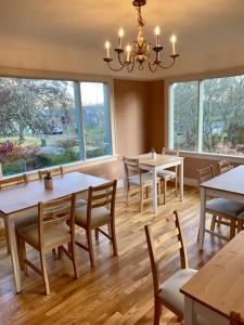 a dining room with tables and chairs and windows at Riverpath Inn in Eugene