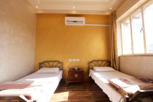 two beds in a room with two windows at Erasmus Student House By Sunrise Hostel in Amman +5 photos