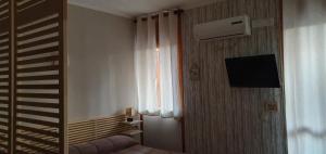 una camera con letto, televisore e finestra di Relax Just Relax Fiuggi a Fiuggi