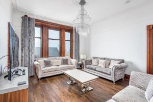 a living room with two couches and a table at Claymore Apartment Broughty Ferry in Dundee