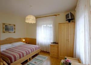 a small bedroom with a bed and a window at Hotel Zoldana in Forno di Zoldo
