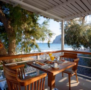 a table with food and a view of the ocean at Alesahne Beach Hotel in Kamari