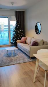a living room with a christmas tree and a couch at Lapland Arctic Apartments in Rovaniemi