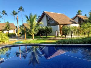 ein Haus mit Palmen und einem Pool in der Unterkunft Bangalô Luxo Malawi Beach Houses in Porto De Galinhas