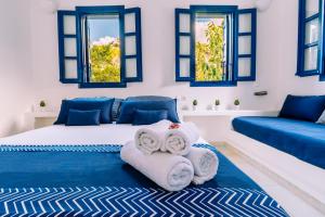 a bedroom with two towels and two windows at Casa Di Roma in Parikia
