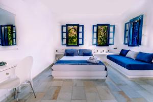 a bedroom with a bed and a couch and windows at Casa Di Roma in Parikia