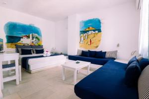 a living room with a blue couch and a bed at Casa Di Roma in Parikia